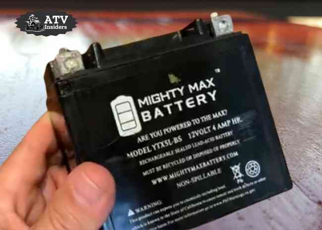Holding Mighty Max battery YTX7A-BS